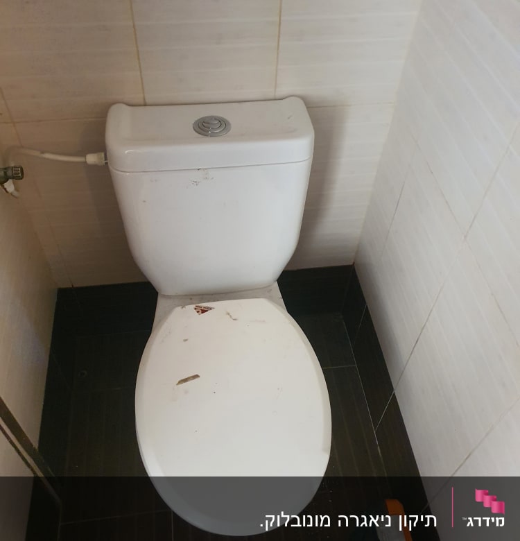 אסלה עם לכלוך וארגז כלים על הרצפה